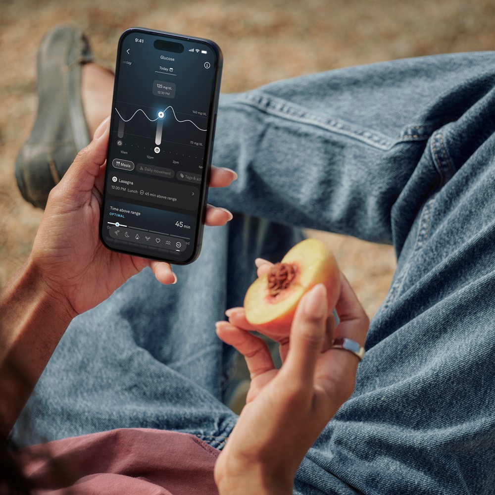 Reviewing Oura Ring 5 metrics in the app over a fresh meal